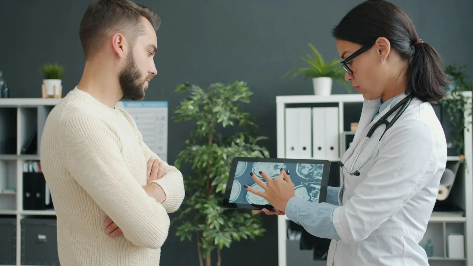A doctor reviews results on a tablet with a patient